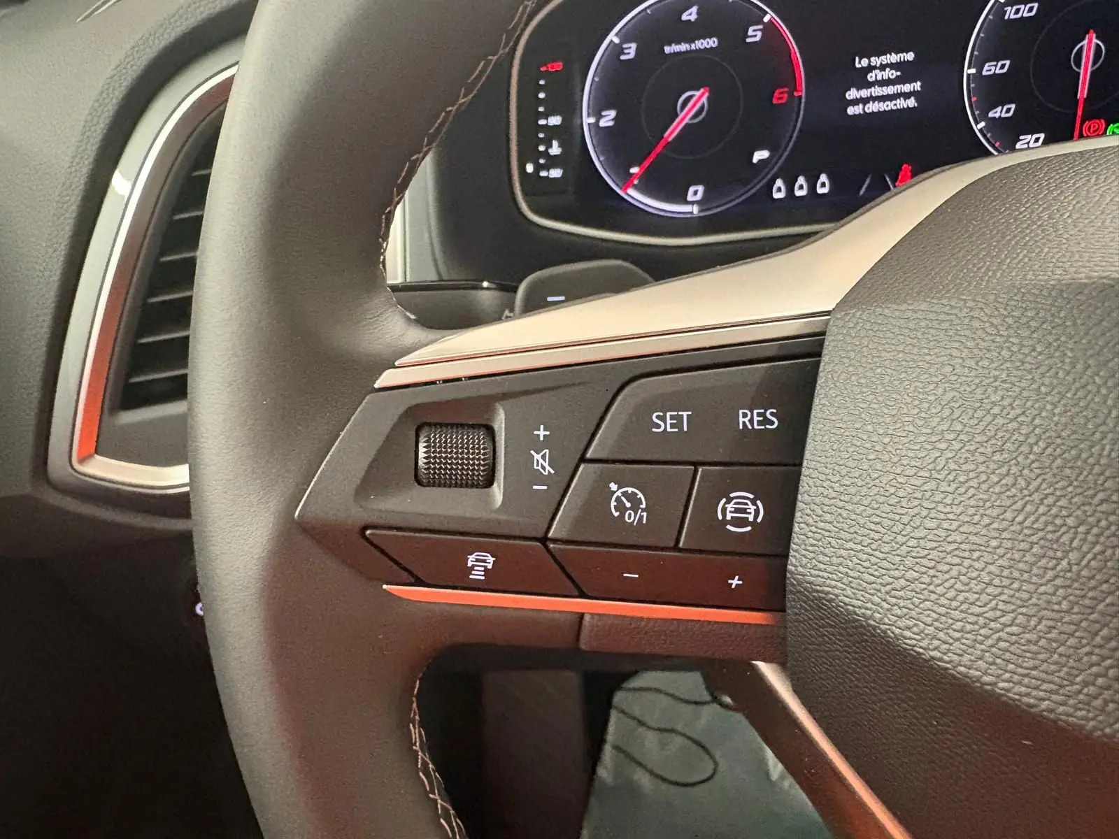 Gros plan sur le volant du SEAT Ateca 2025, montrant les commandes de régulateur et l'affichage du tableau de bord numérique.