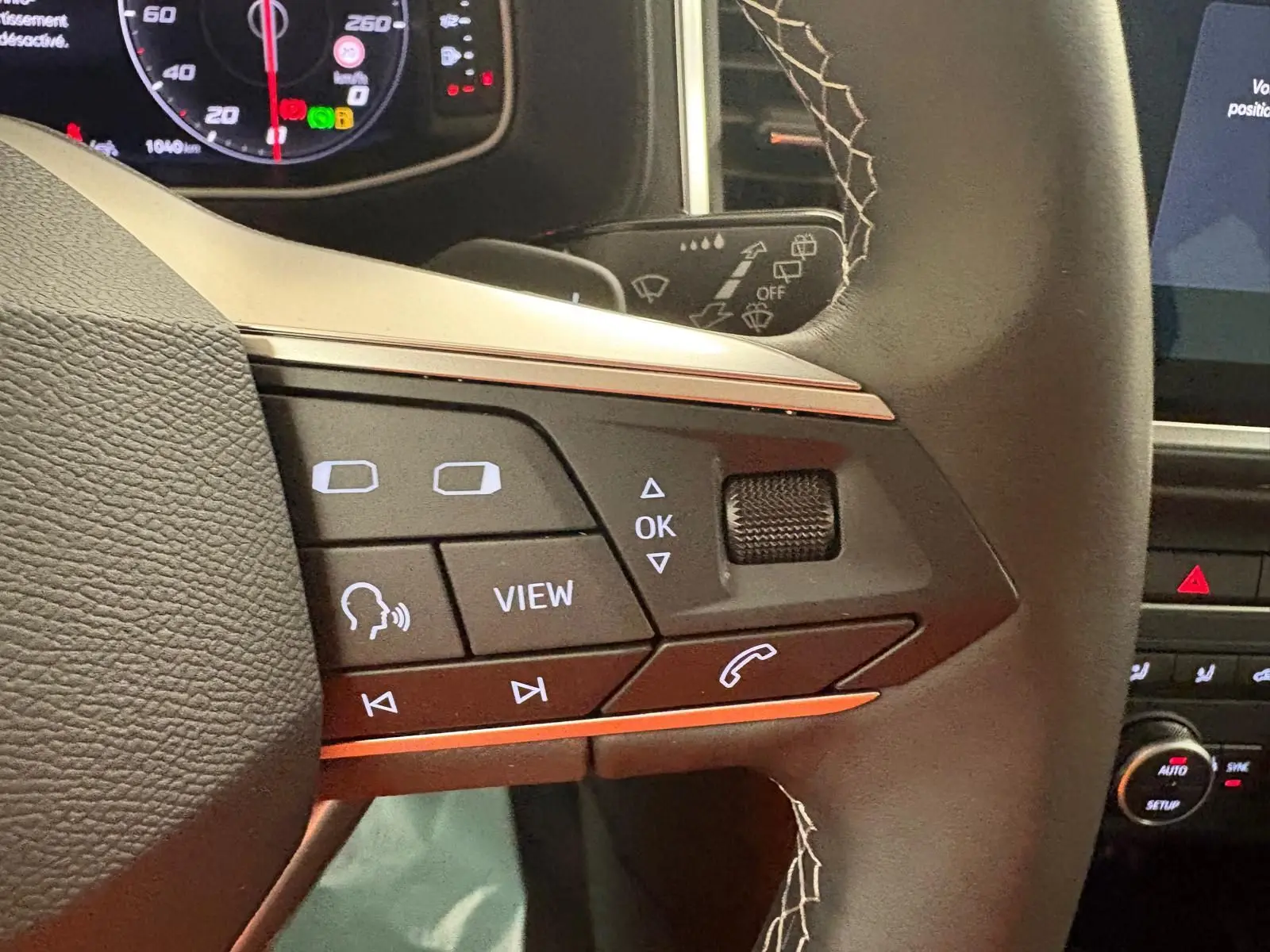 Gros plan sur les commandes multifonctions du volant du SEAT Ateca 2.0 TDI 150 DSG7 COPA, intérieur noir.