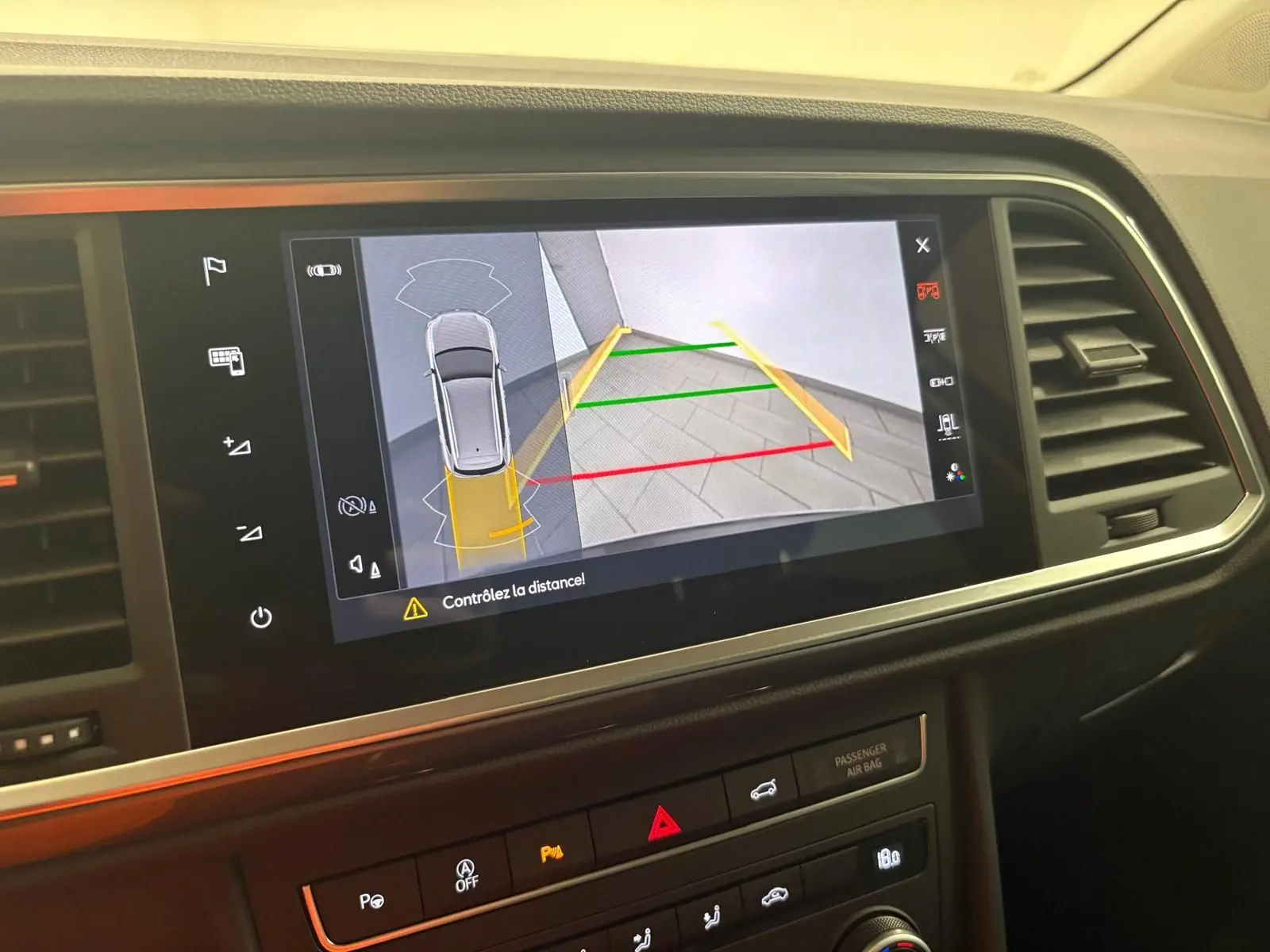 Écran central du tableau de bord du SEAT Ateca montrant la caméra de recul avec guidage de trajectoire coloré.