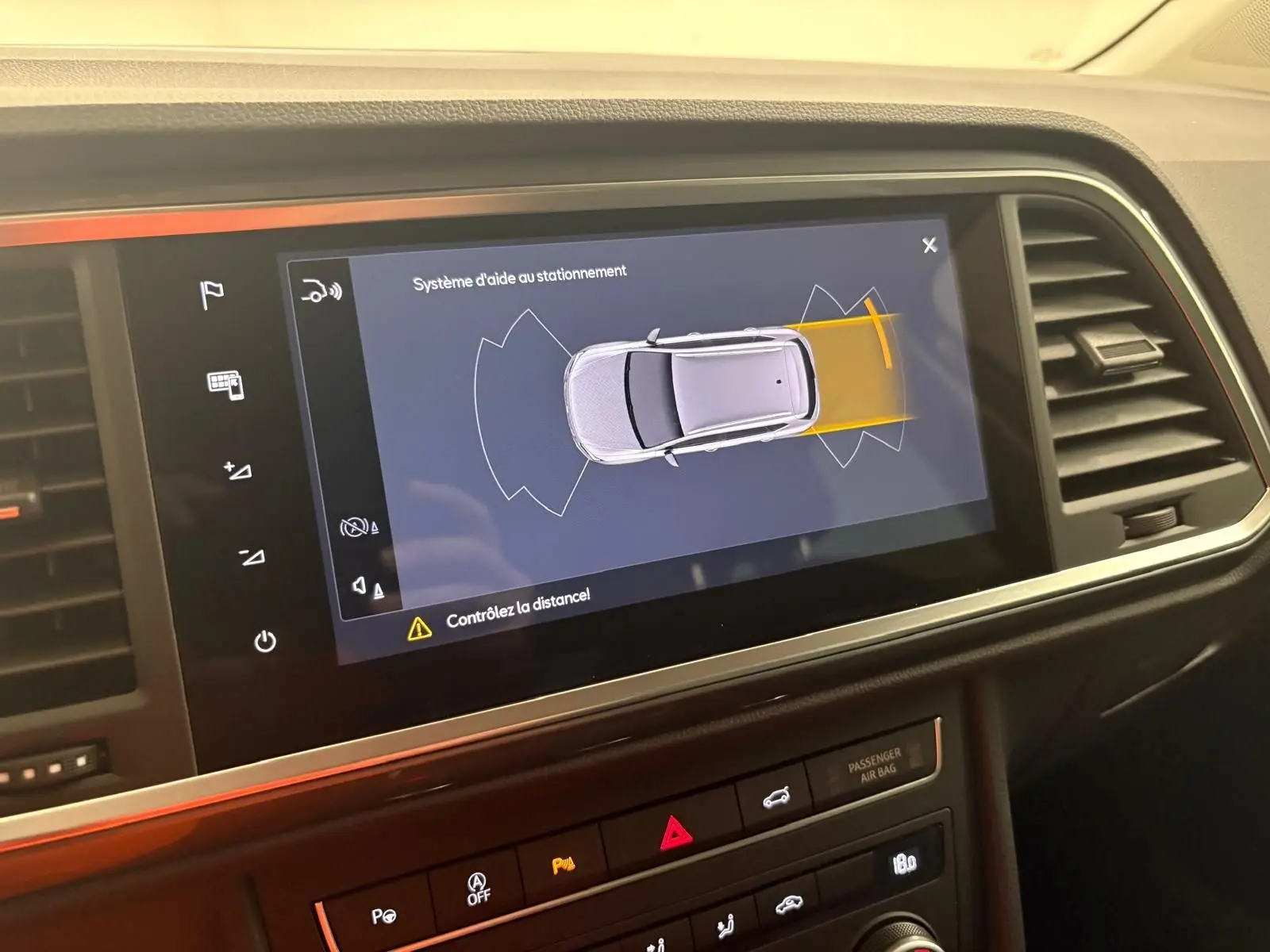 Écran intérieur montrant le système d'aide au stationnement du SEAT Ateca gris graphite, vue de dessus virtuelle du véhicule.