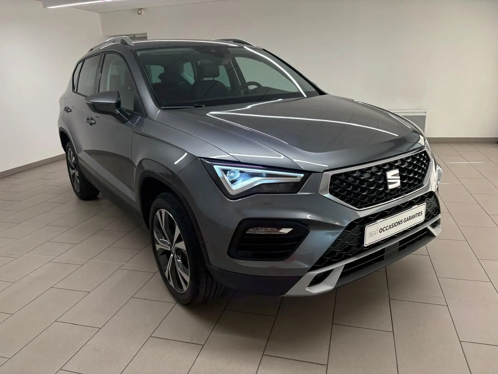 SEAT Ateca 2025 gris graphite en vue 3/4 avant, avec jantes alliage 18'' et calandre noire distinctive.
