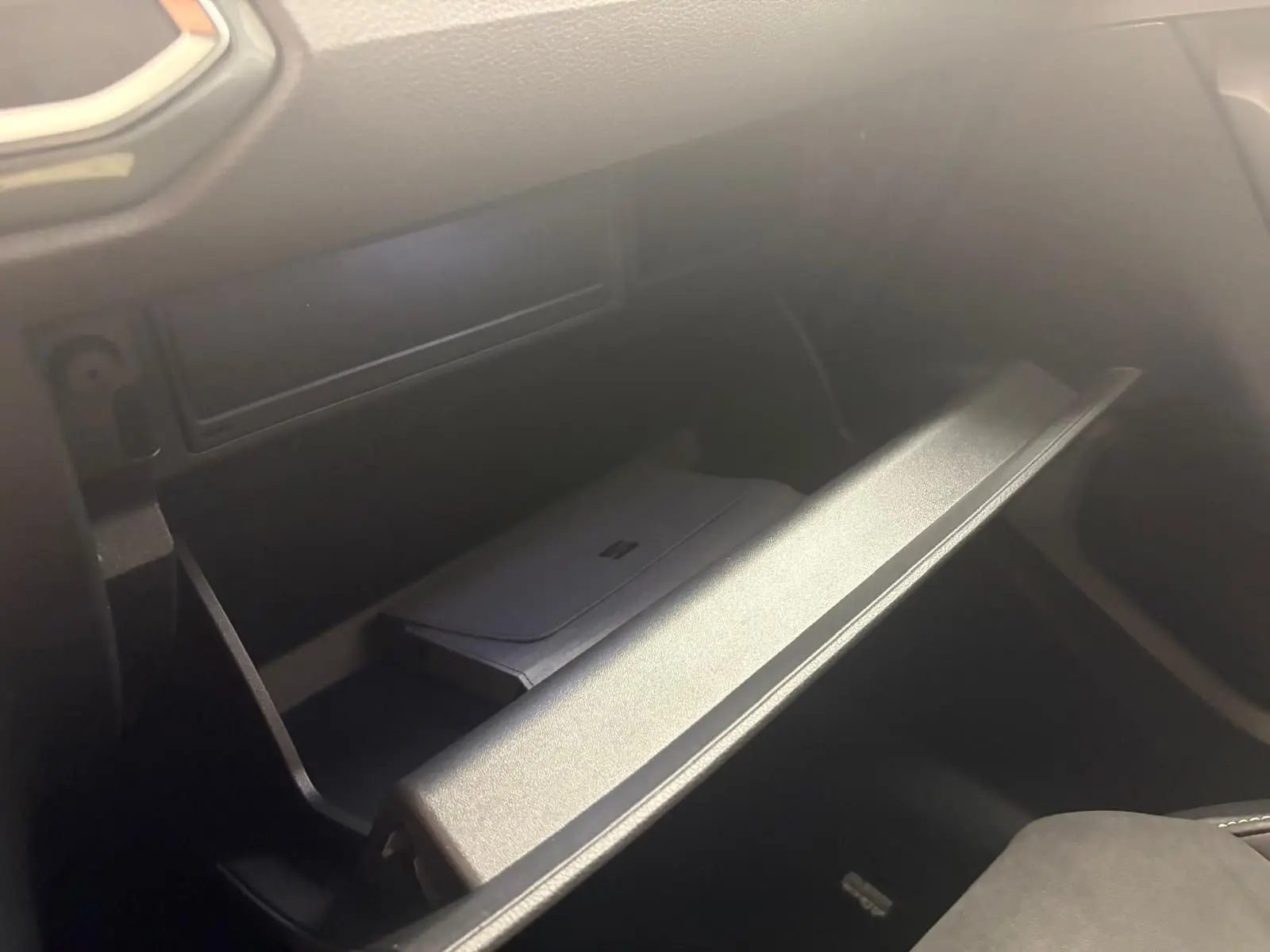 Gros plan sur la boîte à gants ouverte du SEAT Ateca 2.0 TDI 150 DSG7 COPA, intérieur noir.