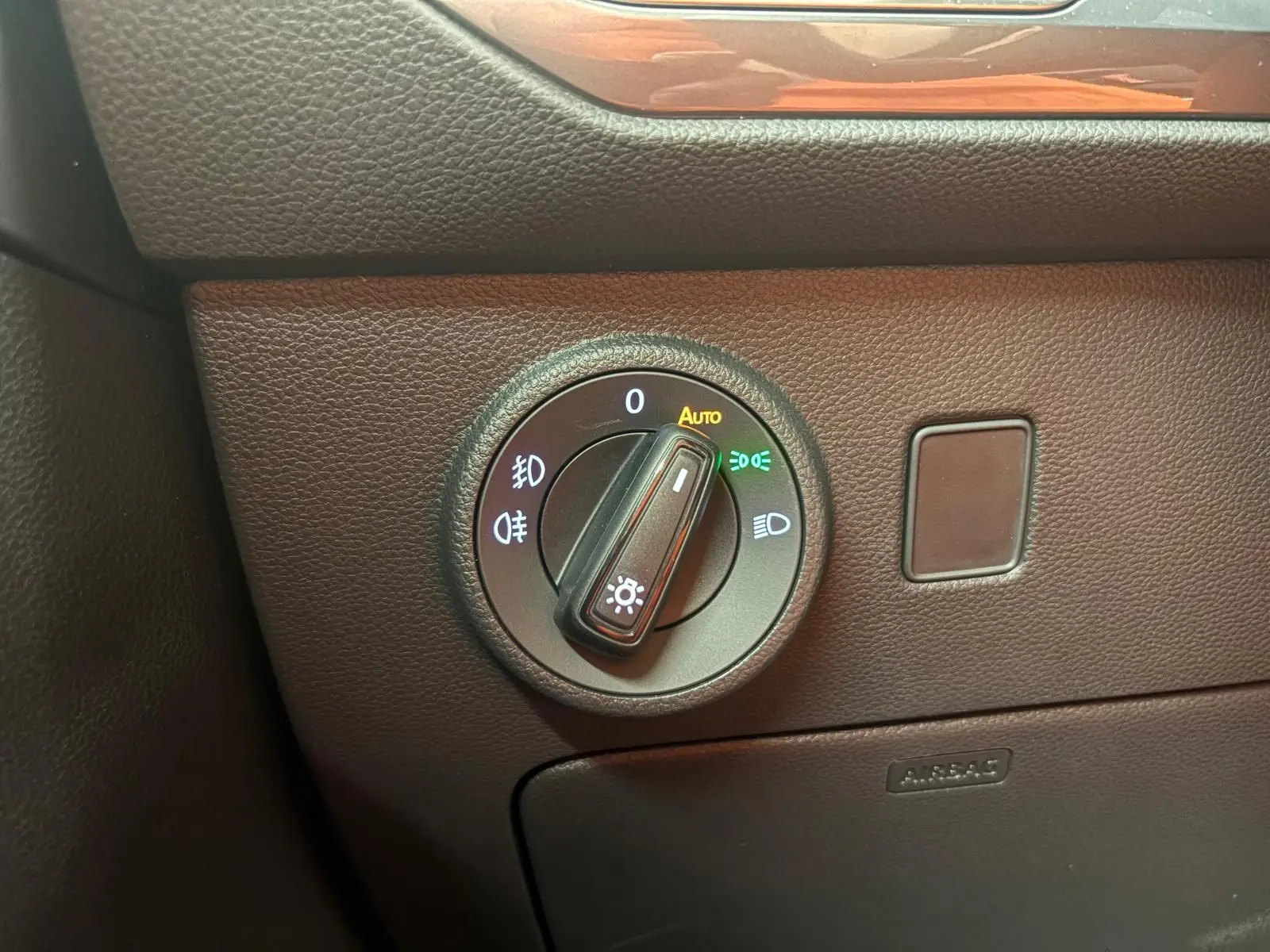 Gros plan sur la molette de réglage des phares dans l’habitacle du SEAT Ateca gris graphite, version 2025.