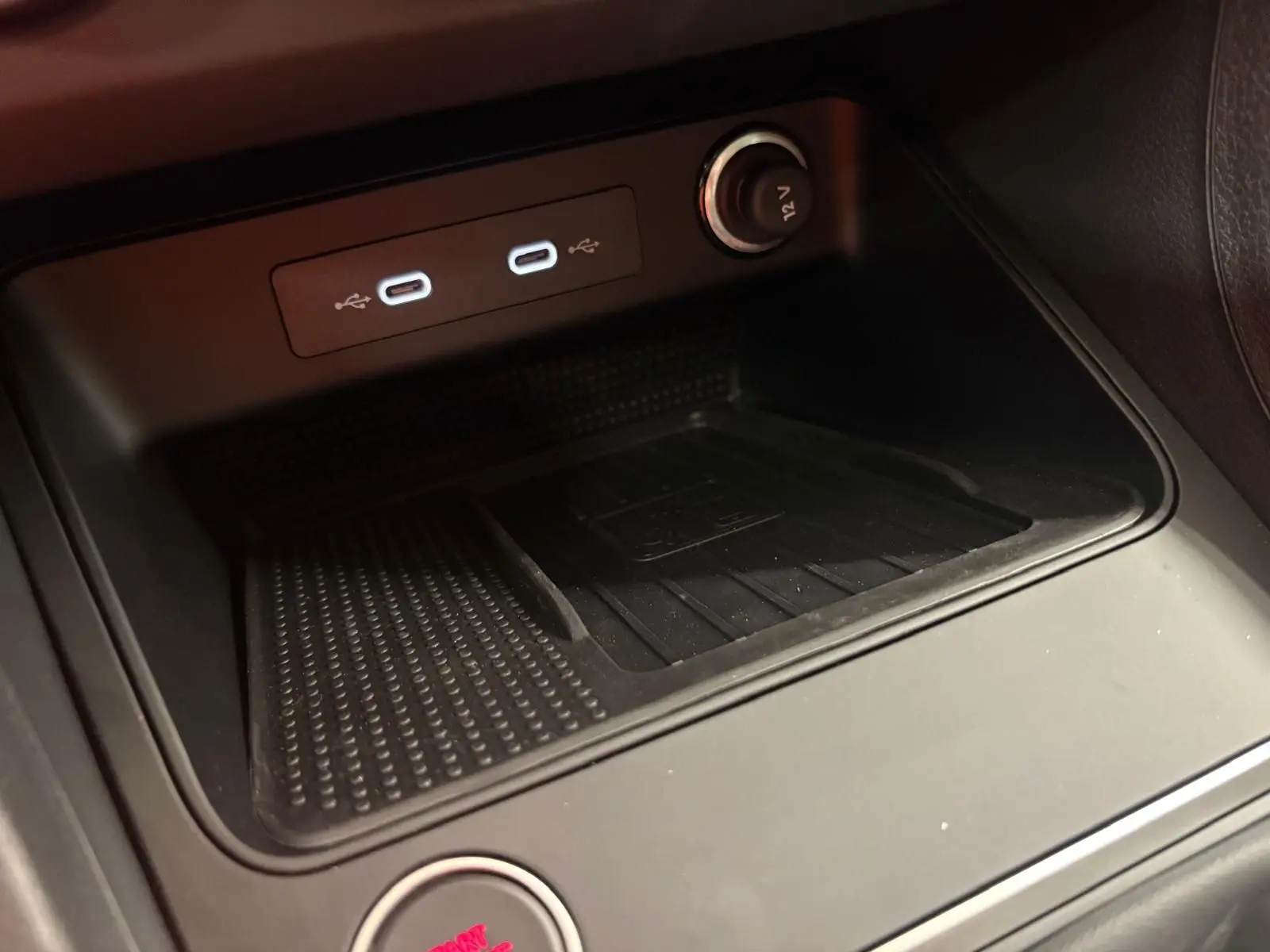 Gros plan sur la console centrale du SEAT Ateca 2025, montrant les ports USB-C et une prise 12V, finition noire.