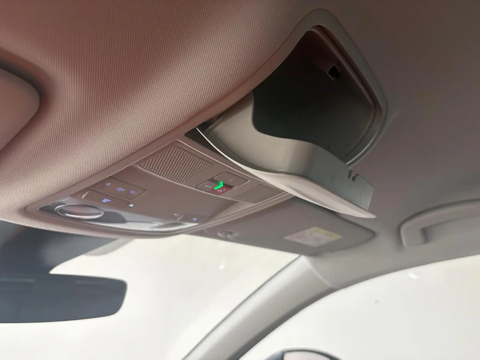 Détail du plafond intérieur du SEAT Ateca 2025 avec rangement lunettes ouvert et commandes éclairage intégrées.