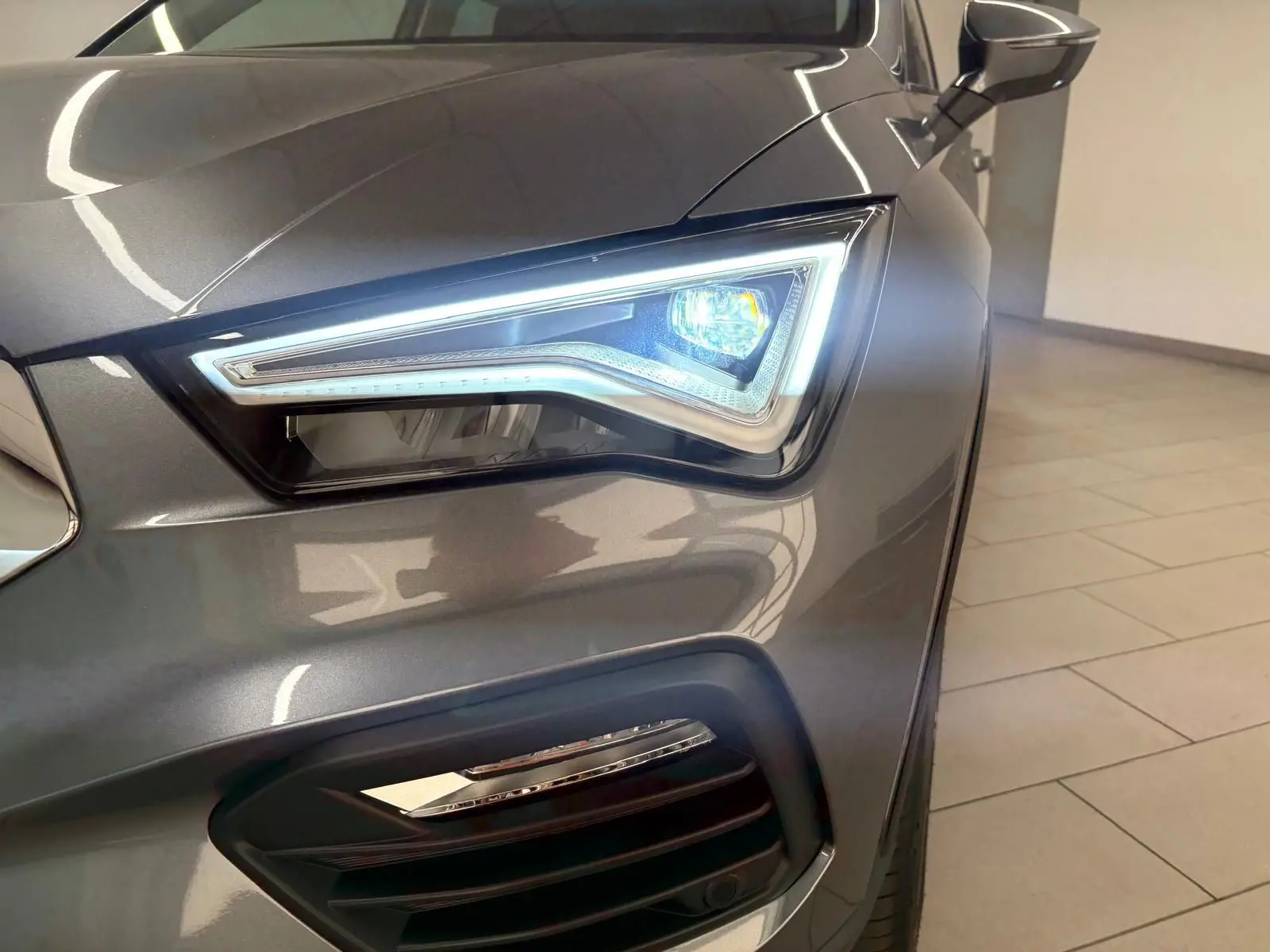 Gros plan sur le phare avant droit allumé du SEAT Ateca 2.0 TDI 150 DSG7 COPA gris graphite 2025.