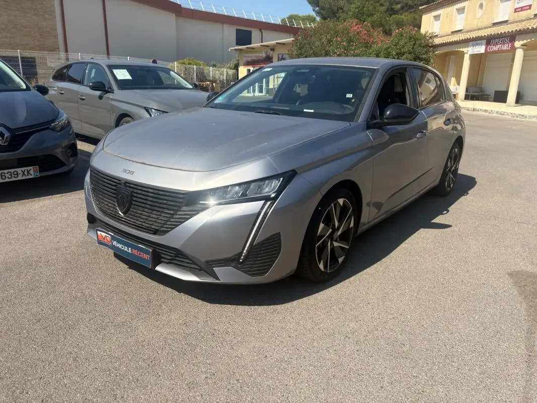 Peugeot 308 PHEV 180 e-EAT8 Allure gris clair vue 3/4 avant avec calandre noire et jantes alliage distinctives.