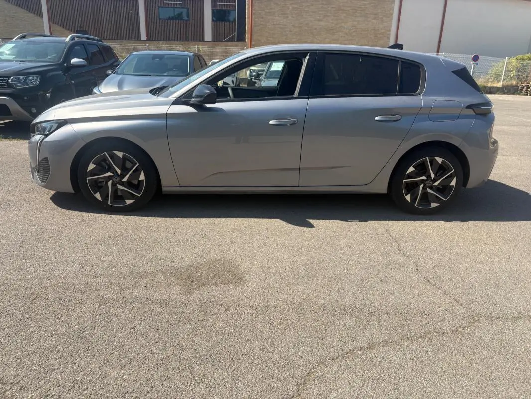 Peugeot 308 PHEV 180 e-EAT8 Allure gris clair vue de profil côté gauche, avec jantes alliage distinctives.