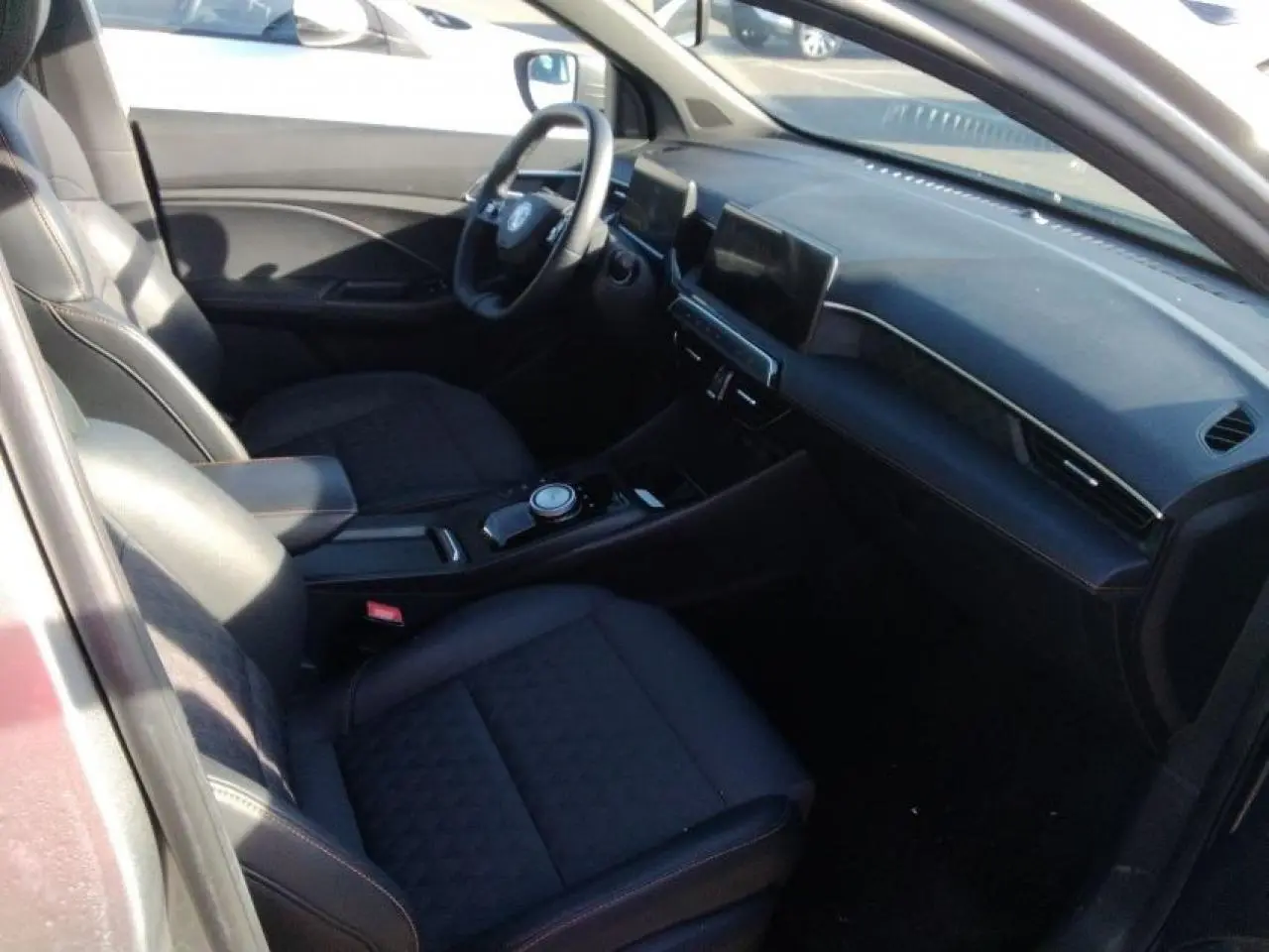 Vue intérieure côté conducteur du MG3 1.5 Hybrid+ 195 Luxury avec sellerie tissu/similicuir noir et écran tactile central.
