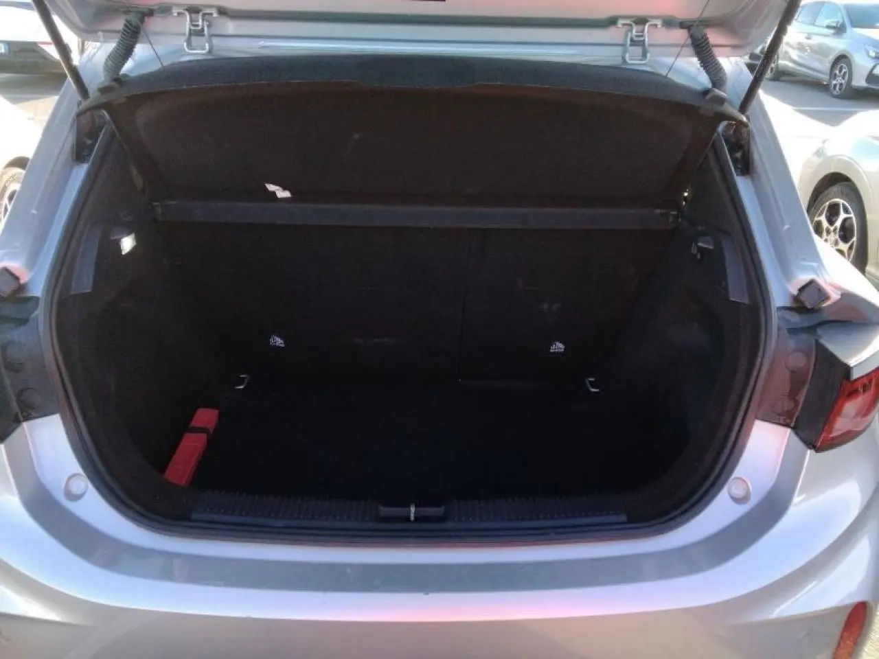 Coffre ouvert vu de l'arrière d'une MG3 1.5 Hybrid+ 195 Luxury argent Cosmic, montrant l'espace de chargement vide.