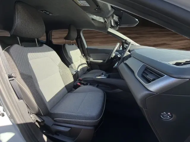 Vue intérieure côté droit de la Renault Symbioz 2025, sièges tissu gris et tableau de bord moderne avec écran tactile.