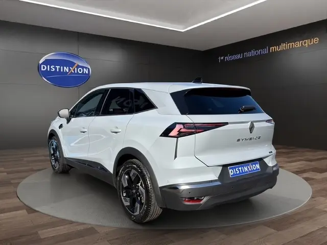Vue 3/4 arrière droite d’un Renault Symbioz gris clair avec feux LED et toit noir en showroom.