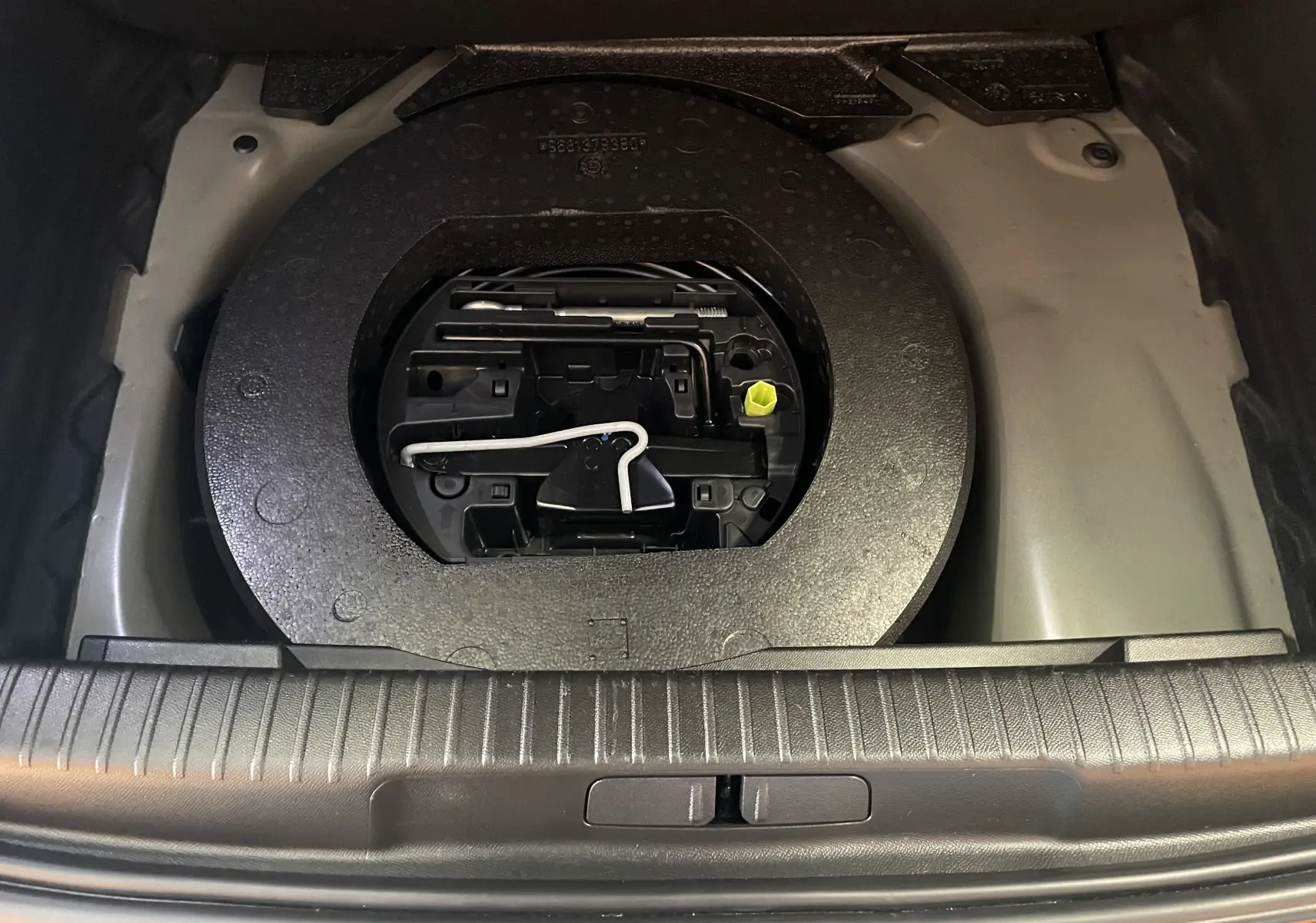 Gros plan sur la roue de secours et les outils dans le coffre du DS3 Crossback 2024 couleur Perla Nera.