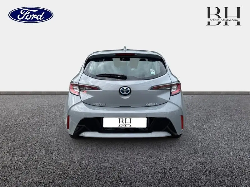 Vue arrière d'une Toyota Corolla 122h Dynamic Business 2020 en gris Manhattan métallisé avec feux arrière LED et logo Toyota visible.