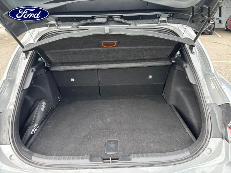Coffre ouvert vu de l'arrière d'une Toyota Corolla gris Manhattan métallisé, montrant un espace de rangement propre.