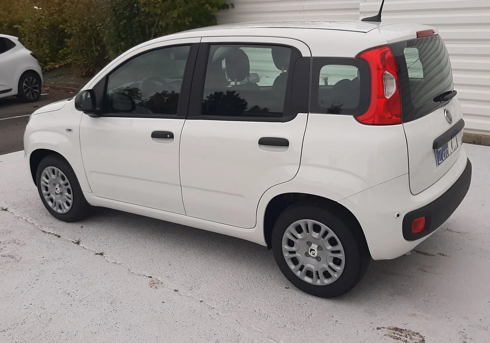 Vue 3/4 arrière droite d'une FIAT Panda blanche Gelato 2025, compacte avec feux arrière rouges et vitres teintées.