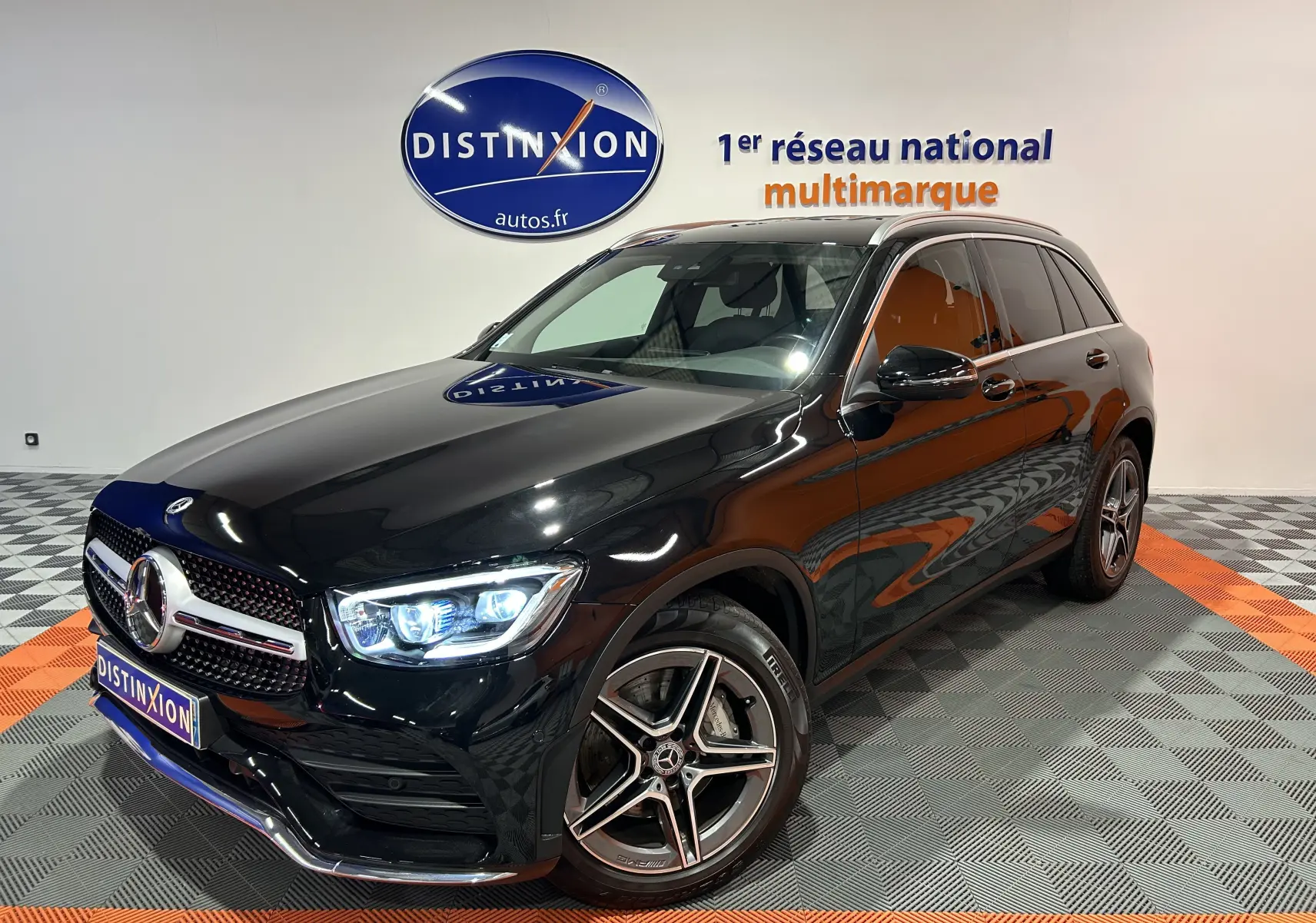 Mercedes GLC 220D AMG Line noir Obsidienne métallisé, vue 3/4 avant avec phares LED allumés et jantes AMG cinq branches.