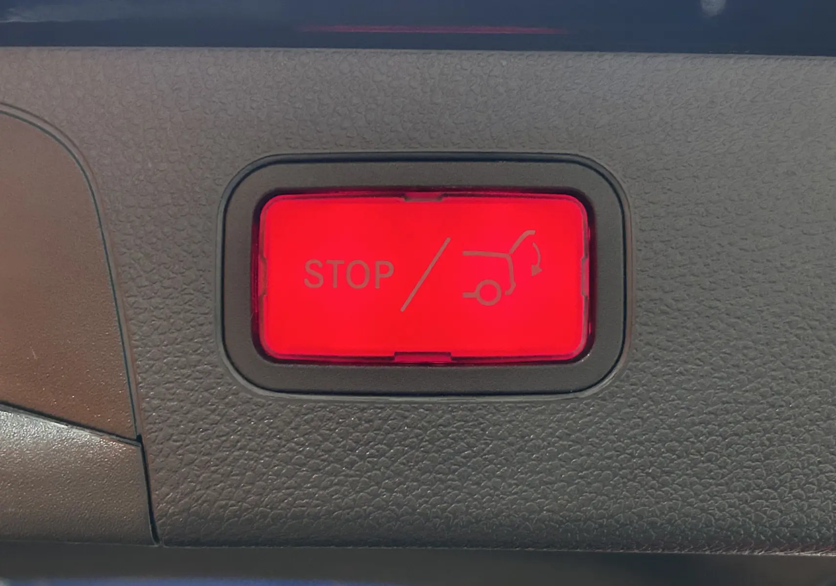 Bouton rouge d'arrêt d'ouverture/fermeture électrique du hayon sur Mercedes GLC noir Obsidienne AMG Line, vue intérieure.