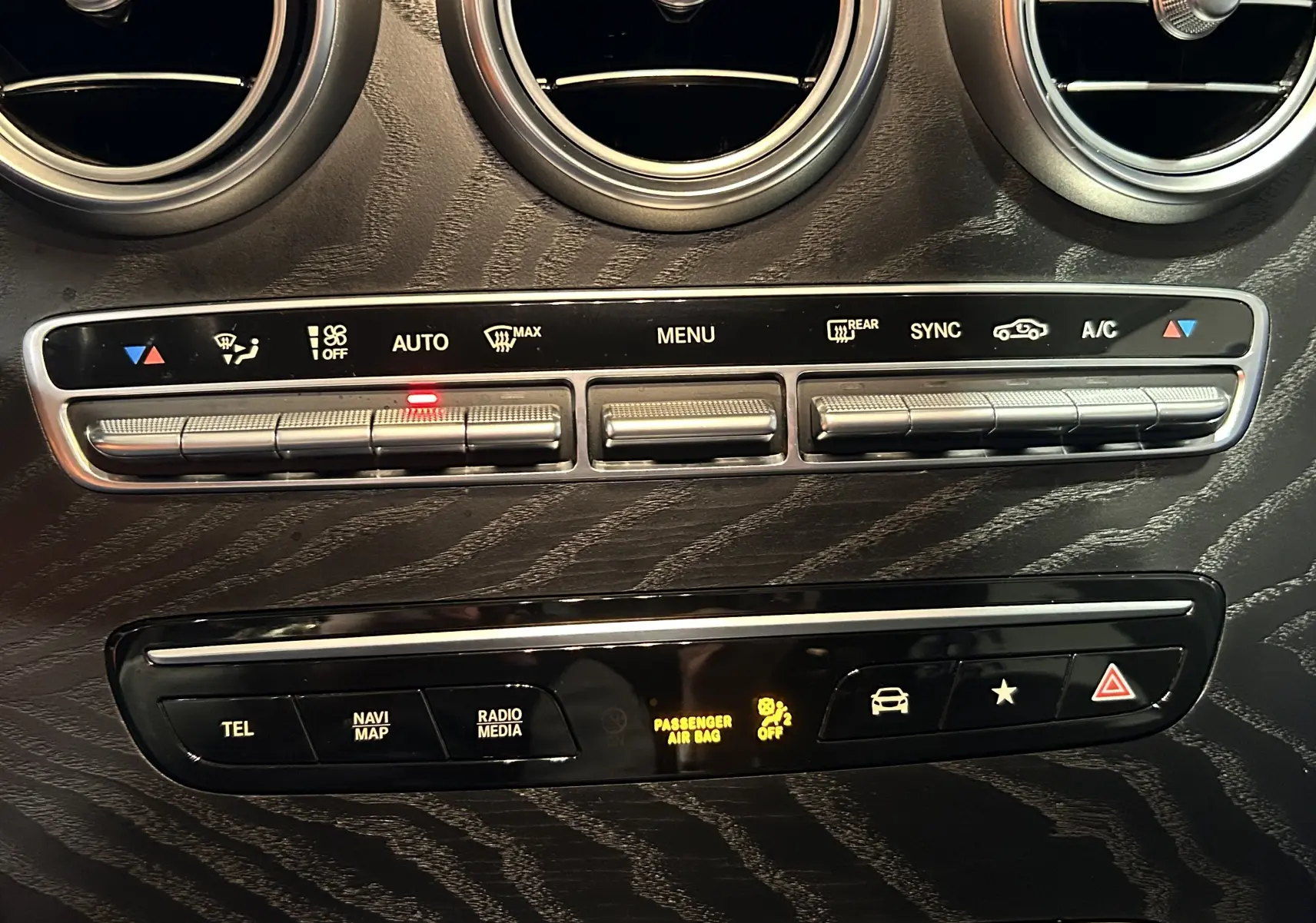 Gros plan sur la console centrale noire du Mercedes GLC 220D AMG Line 2021, avec commandes climatisation et boutons fonctionnels.