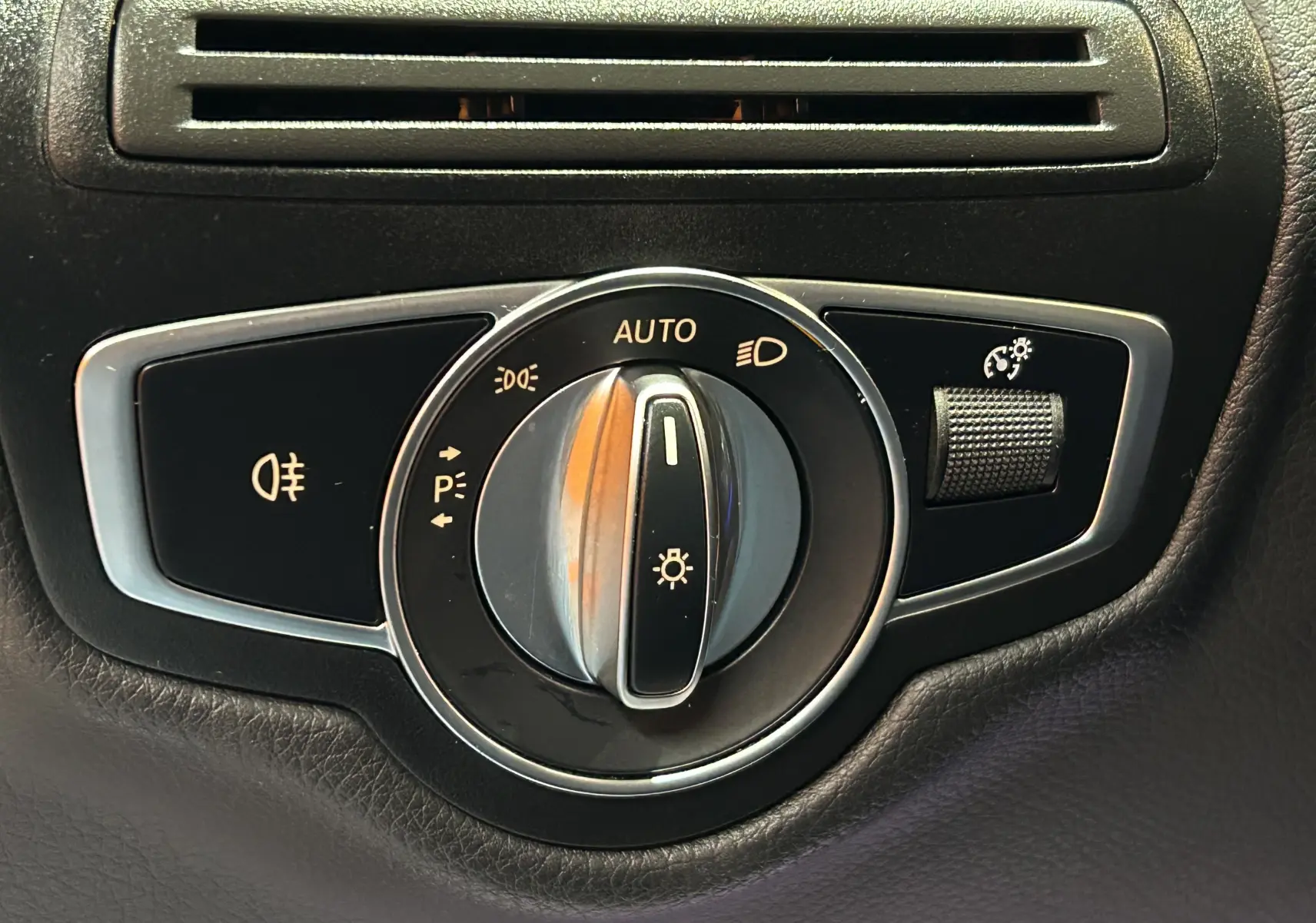 Gros plan sur le sélecteur de phares noir et chrome du Mercedes GLC 220D AMG Line 2021, avec commande d'éclairage automatique.