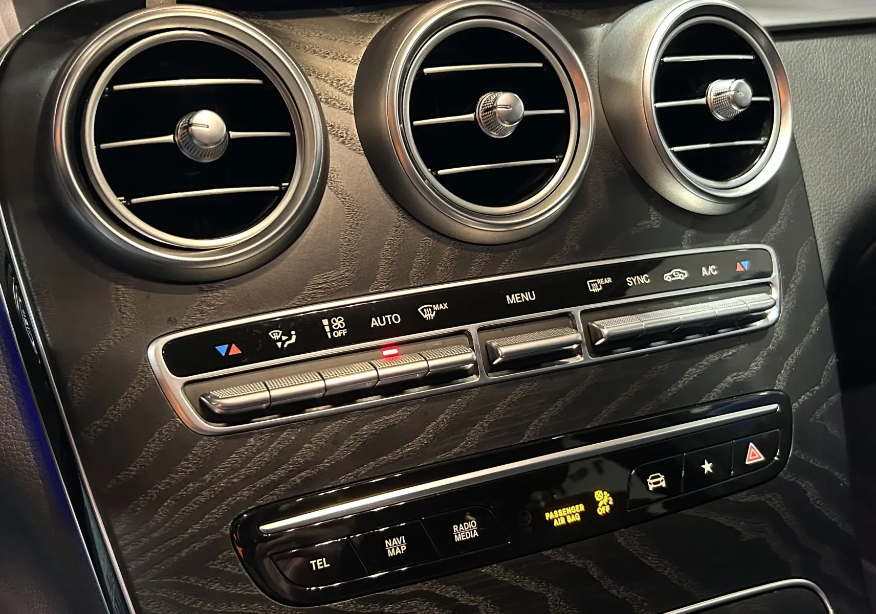 Détail du tableau de bord du Mercedes GLC 220D AMG Line 2021, montrant les aérateurs ronds et commandes de climatisation.