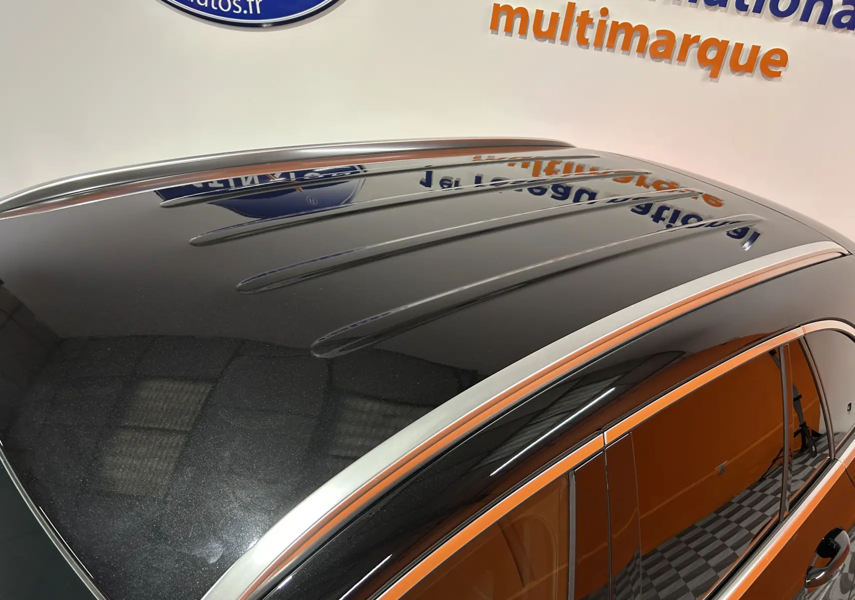 Toit et partie supérieure côté gauche d’un Mercedes GLC 220D AMG Line noir Obsidienne métallisé avec barres de toit chromées.