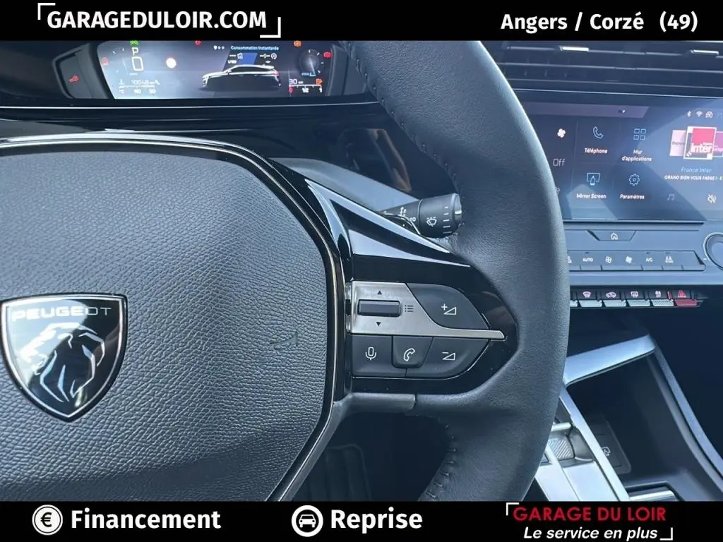 Gros plan sur le volant cuir noir de la Peugeot 308 2023 avec commandes multifonctions et tableau de bord digital.