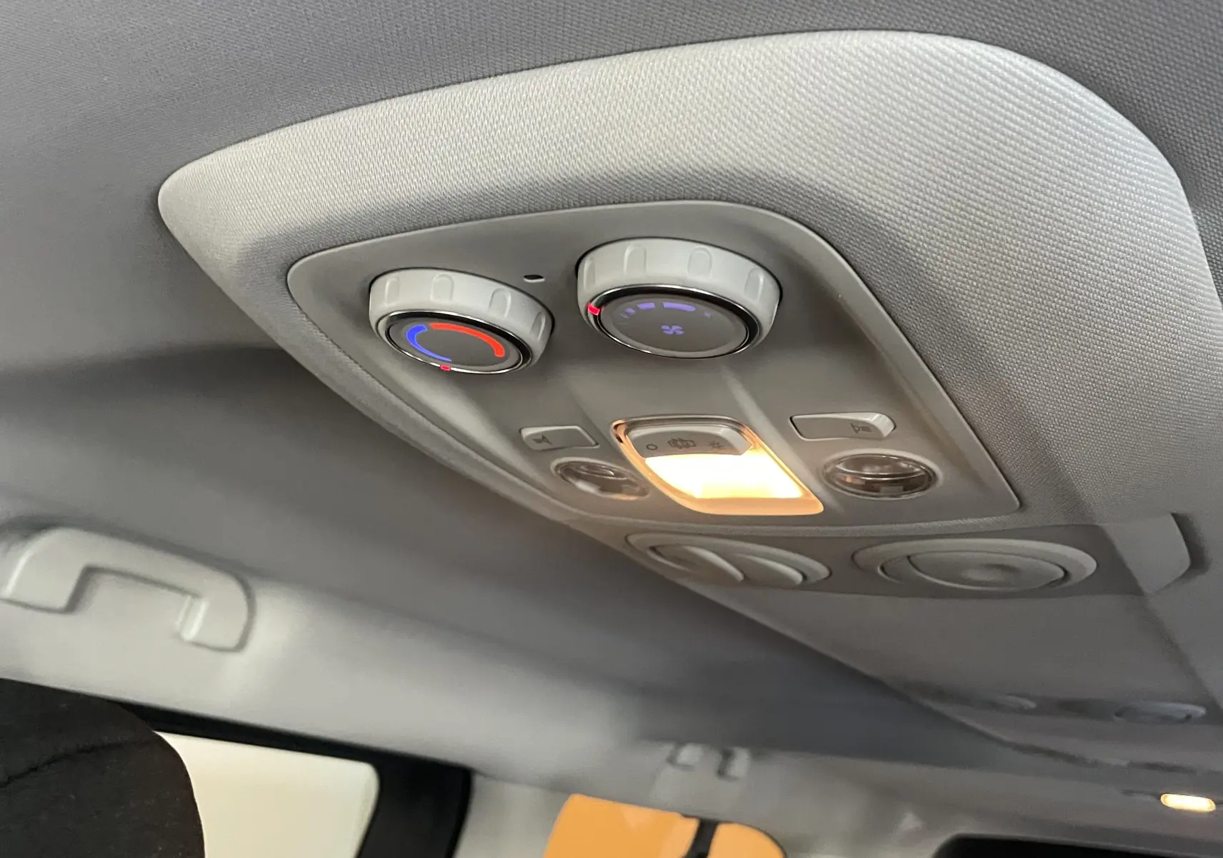 Vue intérieure du plafond arrière du Peugeot Traveller noir 2026, avec commandes de climatisation et éclairage intégré allumé.