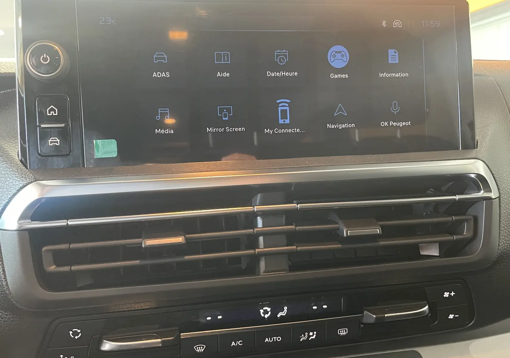 Vue rapprochée de l’écran tactile central et des commandes de climatisation du Peugeot Traveller noir 2026.