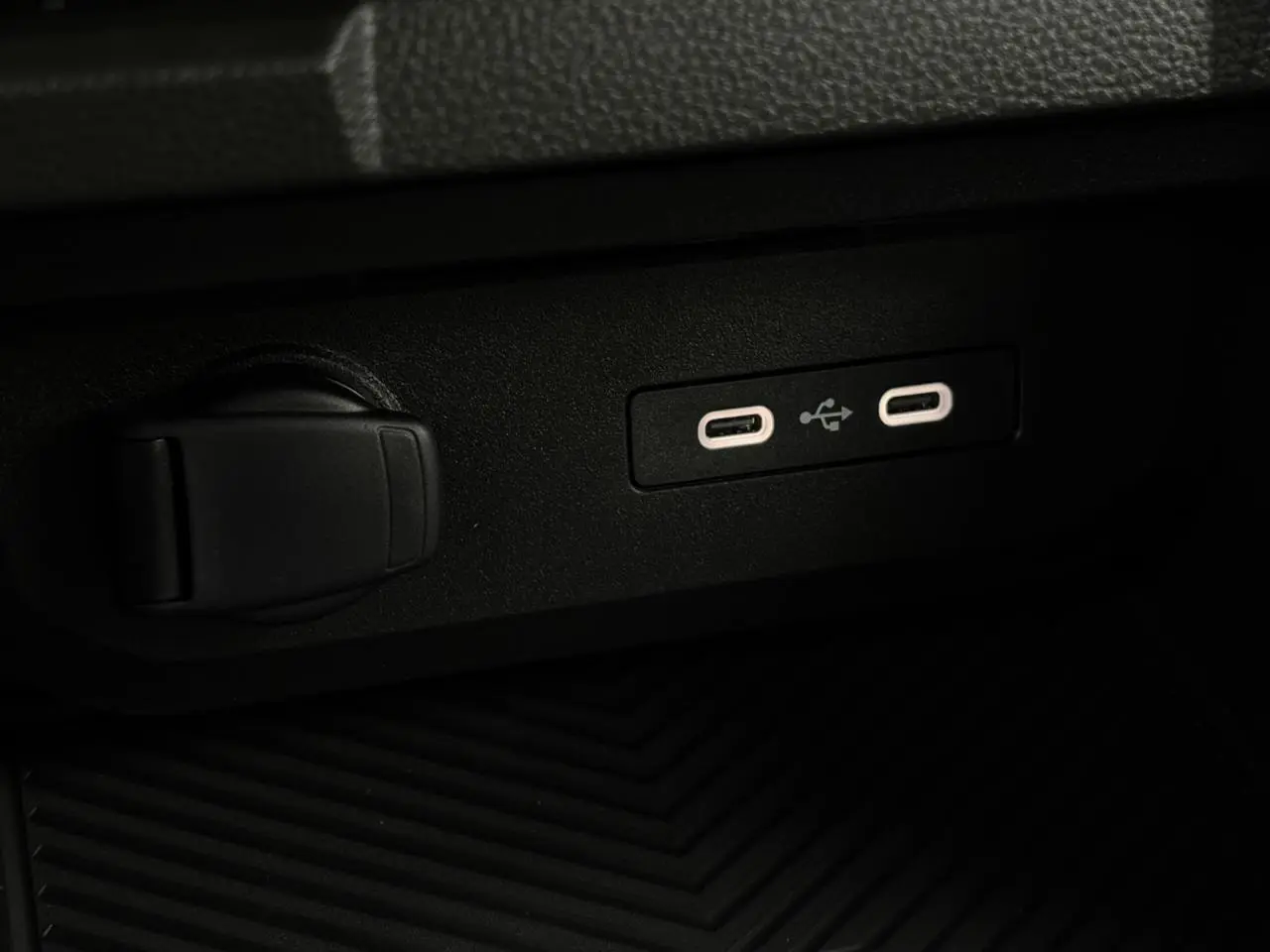 Gros plan sur les deux ports USB-C et prise 12V dans l'habitacle du Dacia Duster gris Schiste 2026.