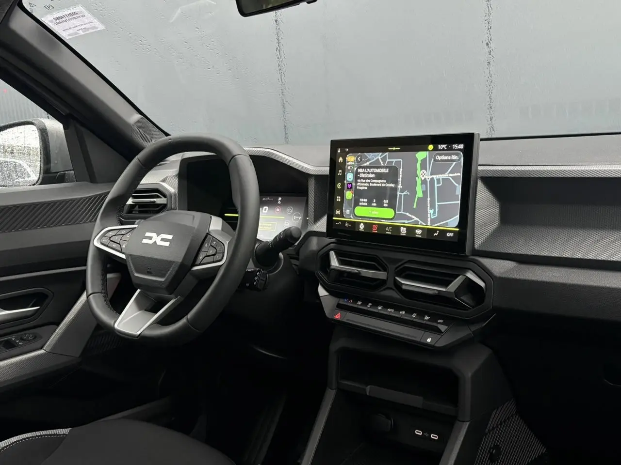 Vue intérieure côté conducteur du Dacia Duster 2026 gris Schiste, avec tableau de bord digital et écran tactile central.