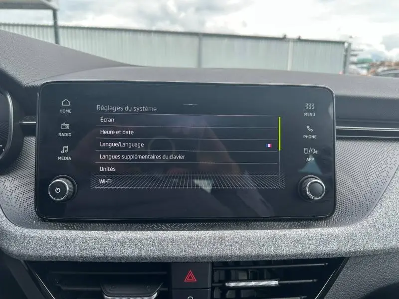 Écran tactile central du tableau de bord de la Skoda Scala gris argent, affichant les réglages du système.
