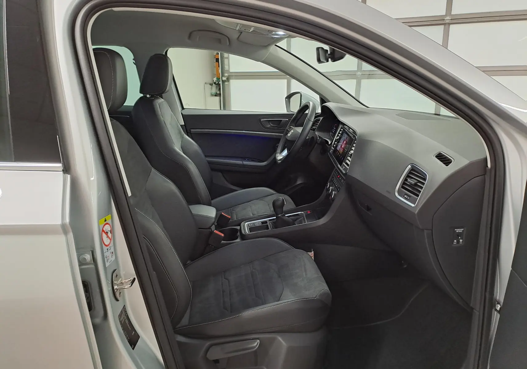 Vue intérieure côté conducteur du SEAT Ateca 2.0 TDI 150 DSG7 Copa argent, avec sièges noirs et tableau de bord moderne.