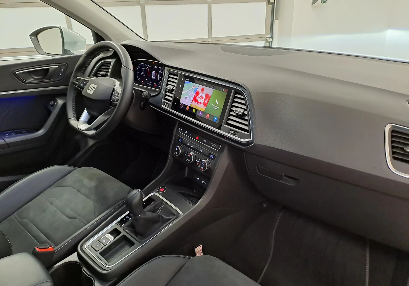 Intérieur du SEAT Ateca 2025 vu côté conducteur, tableau de bord moderne avec écran tactile et sellerie noire.
