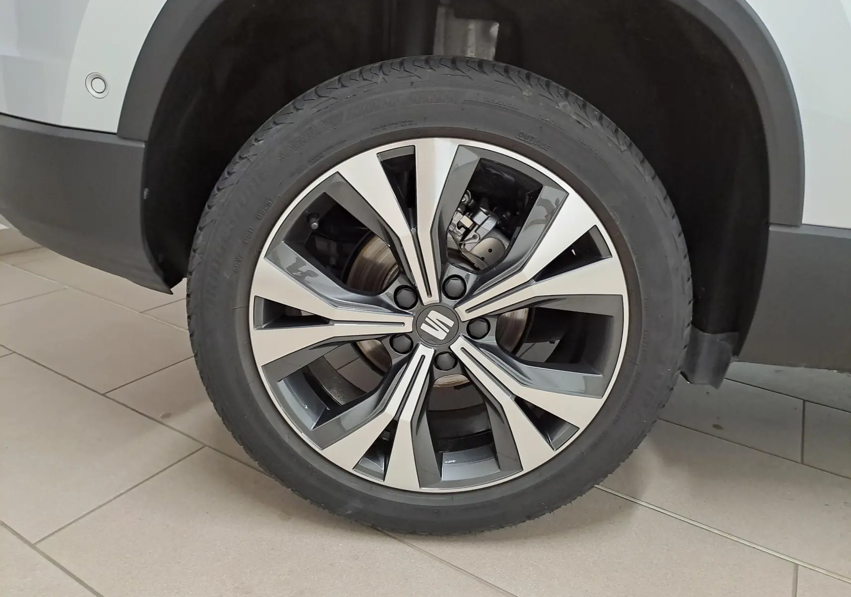 Gros plan sur la jante alliage 18'' usinée du côté gauche d'un SEAT Ateca 2.0 TDI argent métallisé.