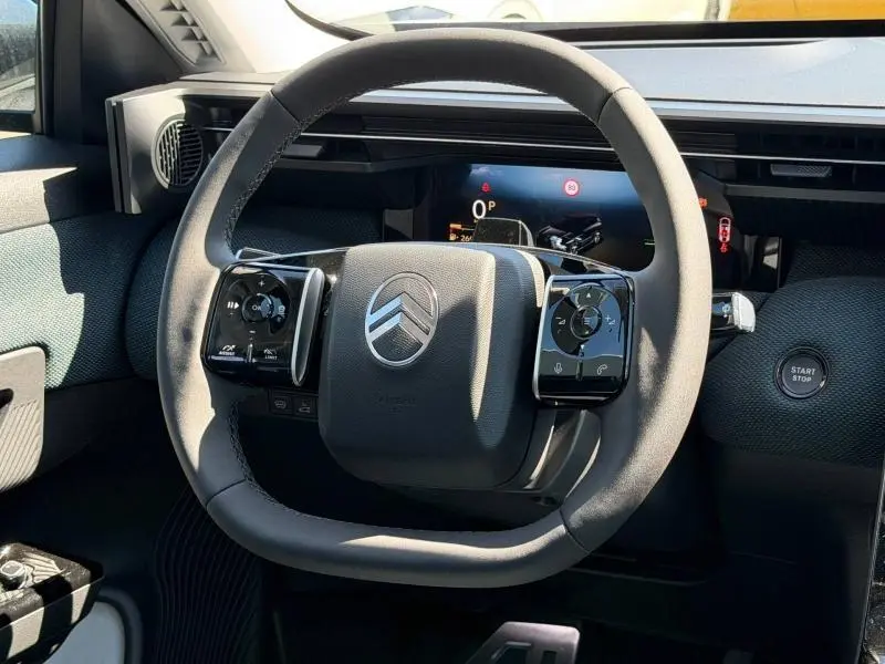 Vue rapprochée du volant noir du Citroën C5 Aircross 2026 avec commandes intégrées et bouton start/stop visible.