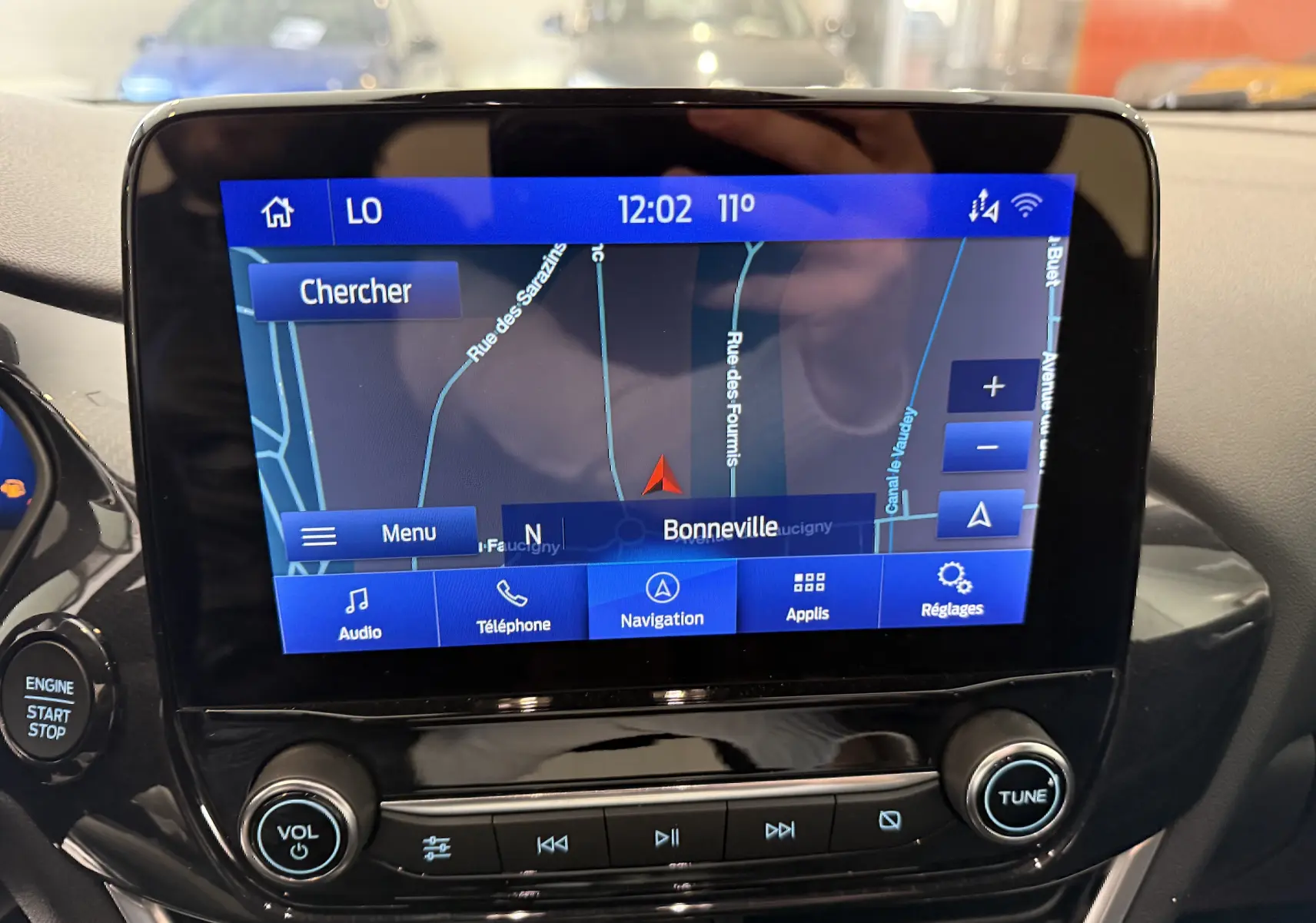Écran tactile central du Ford Puma 2022 montrant la navigation GPS sur fond noir brillant avec commandes audio en dessous.