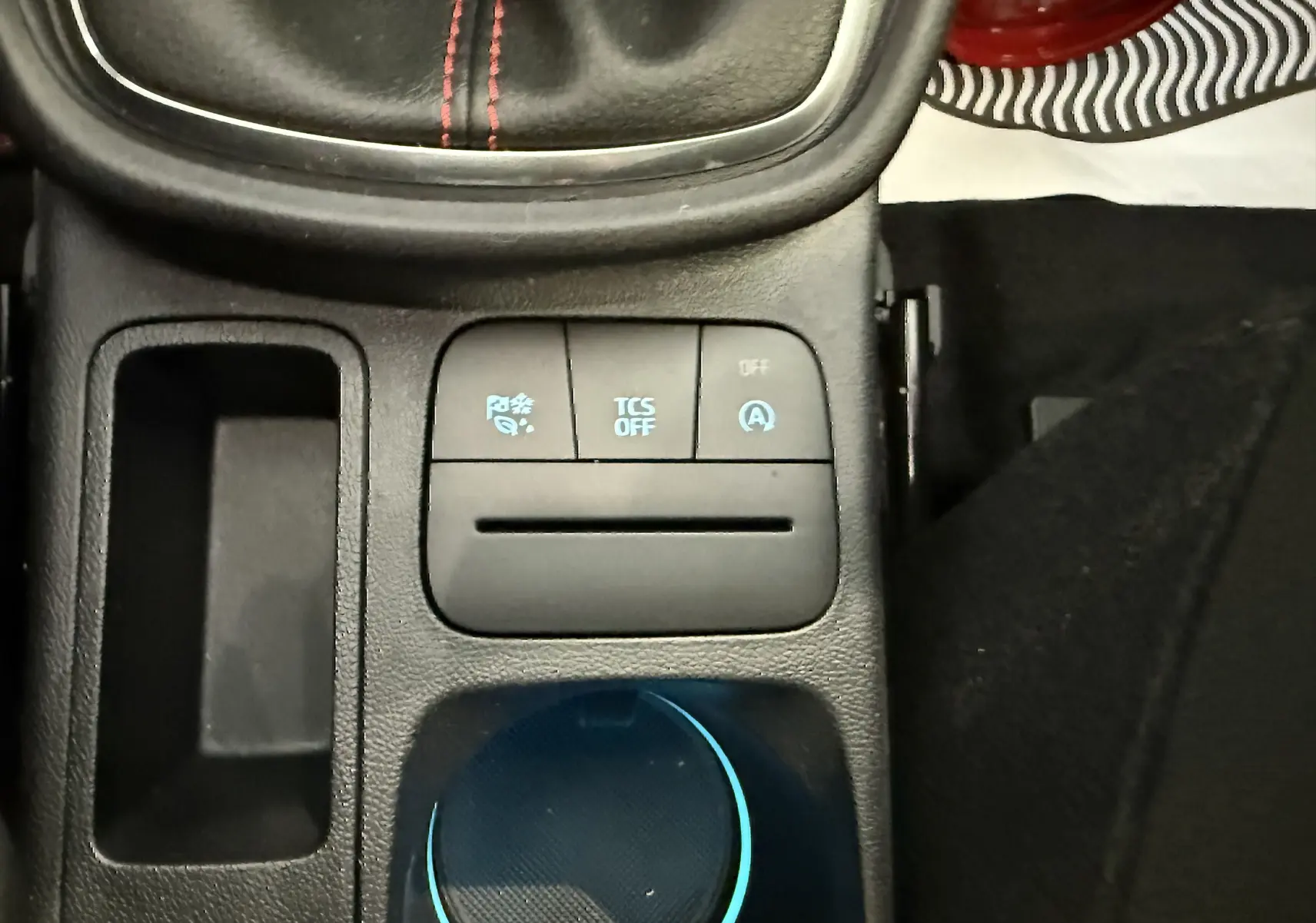 Gros plan sur la console centrale du Ford Puma 2022, montrant les boutons de contrôle et un espace de rangement noir.