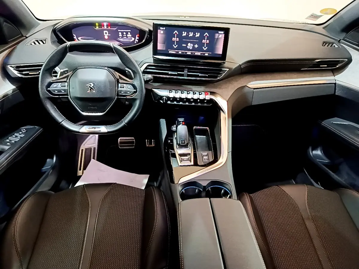 Intérieur Peugeot 3008 GT 2023 vu de face, tableau de bord moderne avec écran tactile central et volant compact cuir.