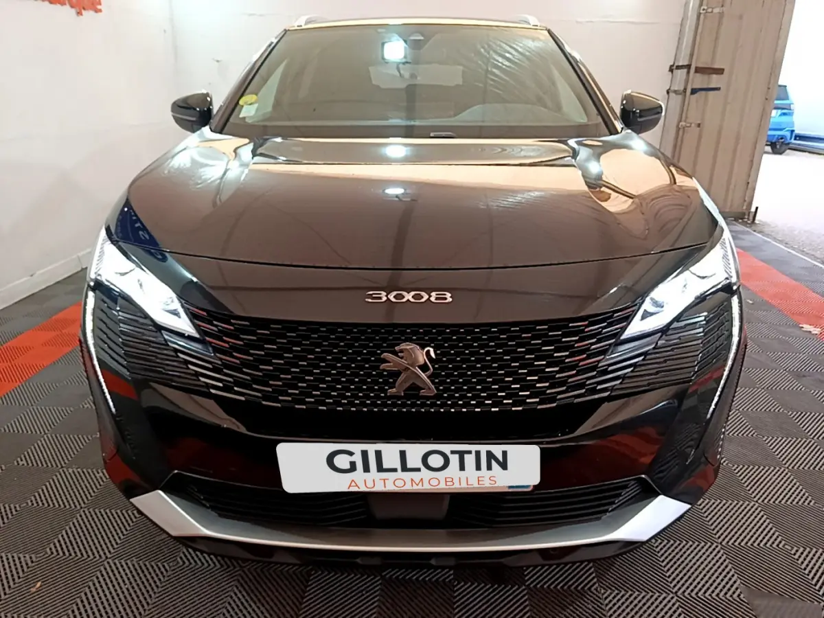 Vue frontale d'un Peugeot 3008 noir 2023 avec calandre noire distinctive et phares LED allumés.
