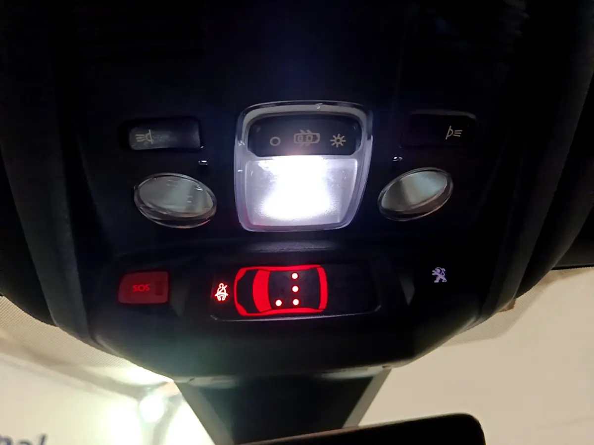 Vue en gros plan du plafonnier intérieur avec commandes lumineuses et bouton SOS du Peugeot 3008 noir 2023.