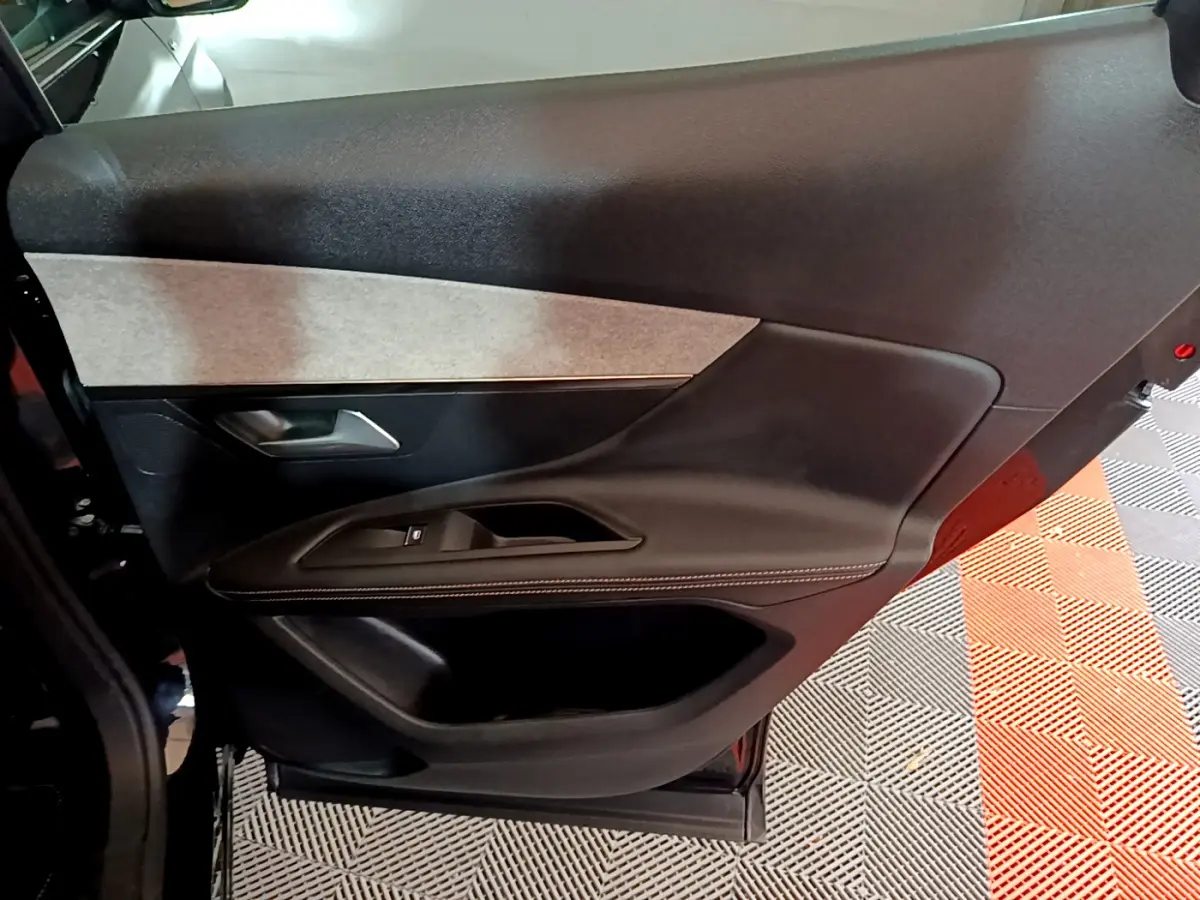 Gros plan sur la porte intérieure côté gauche noire et grise du Peugeot 3008 GT 2023 avec surpiqûres blanches.