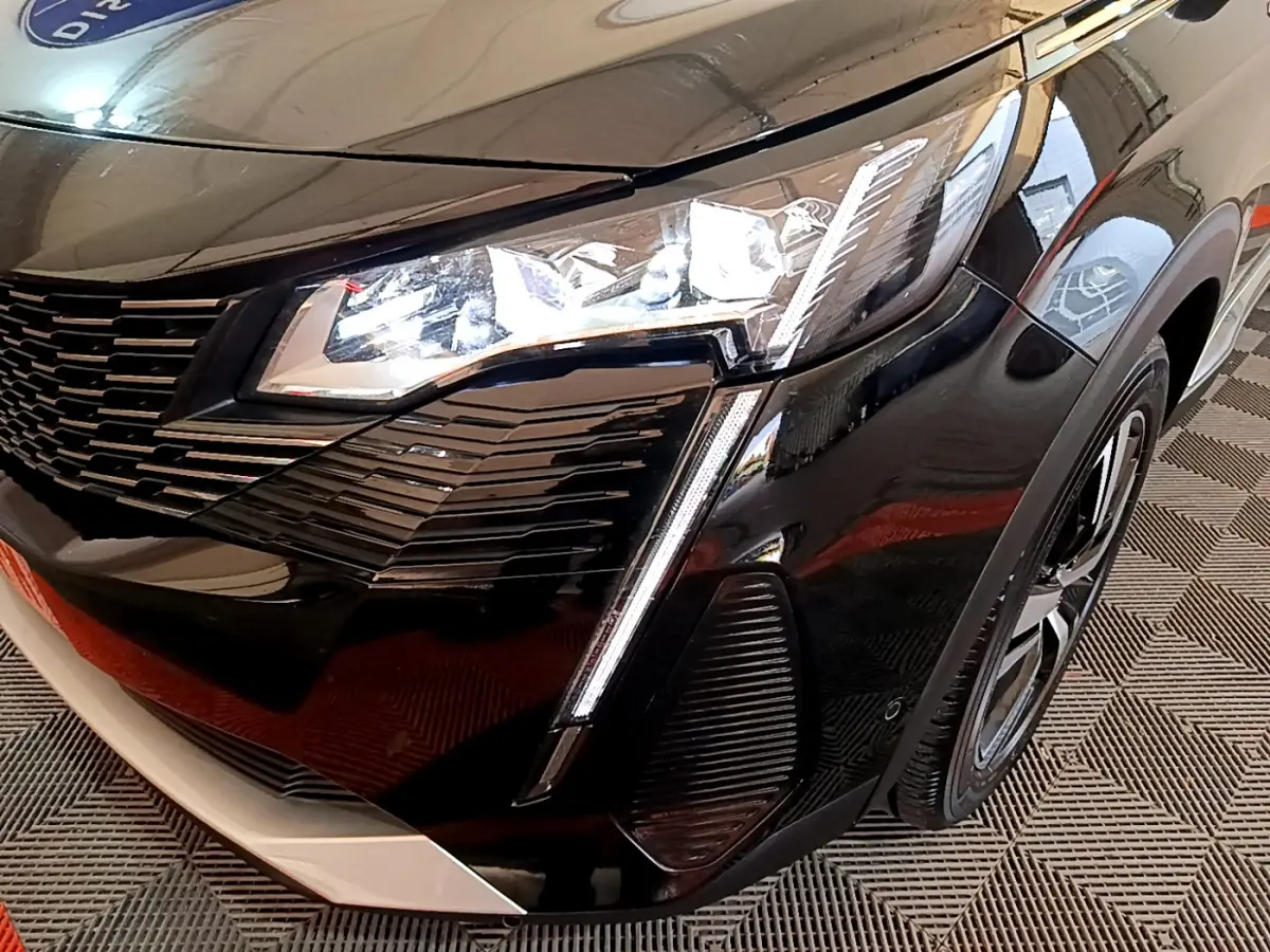 Gros plan sur l'avant droit noir brillant du Peugeot 3008 2023 avec phares LED et calandre distinctive.