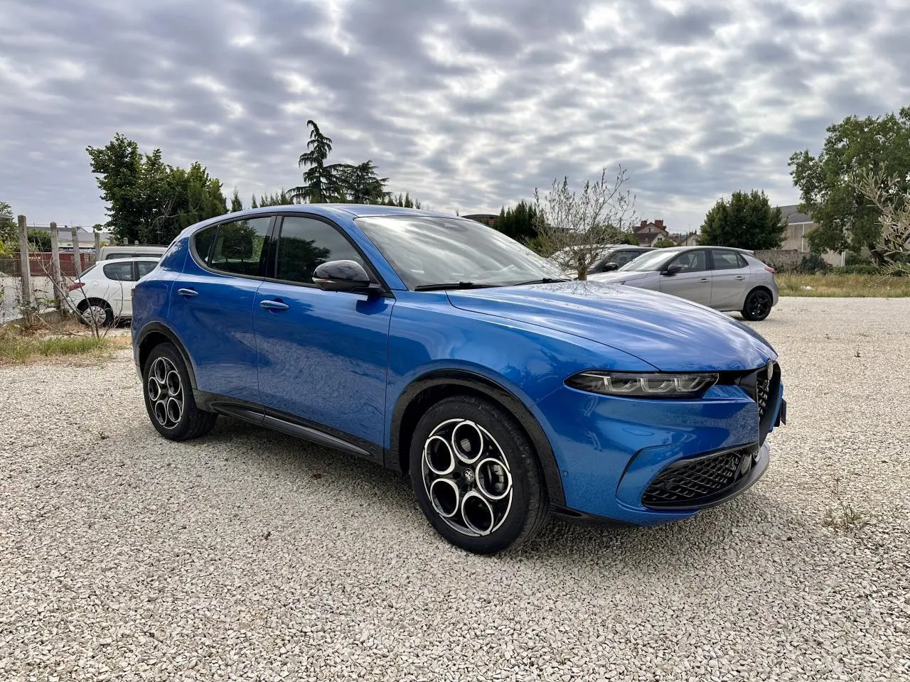Alfa Romeo Tonale bleu métallisé vue 3/4 avant droit, avec jantes distinctives et calandre caractéristique.