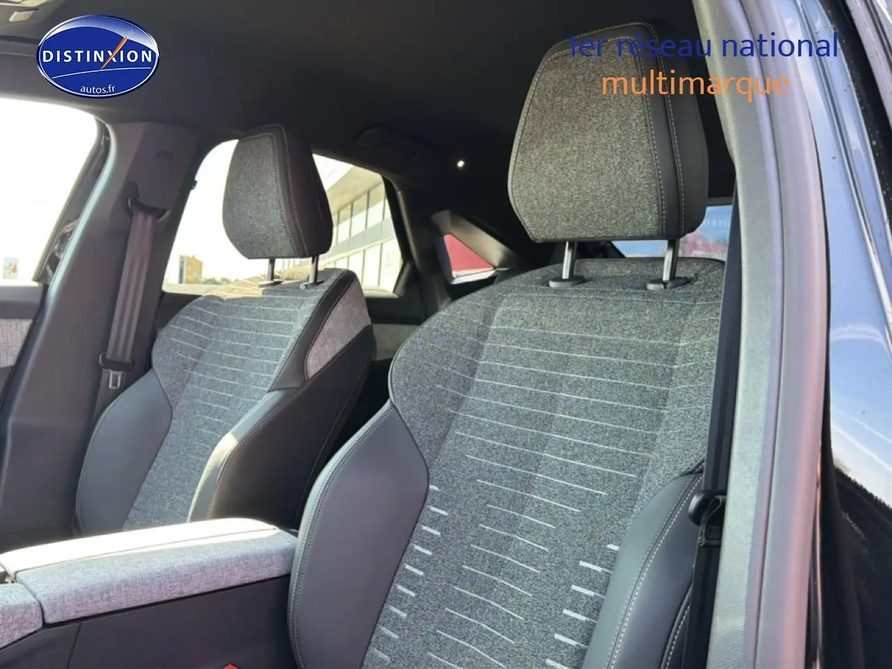 Vue intérieure rapprochée des sièges avant en tissu gris et cuir noir du Peugeot 3008 1.2 Hybrid 145 Allure 2025.