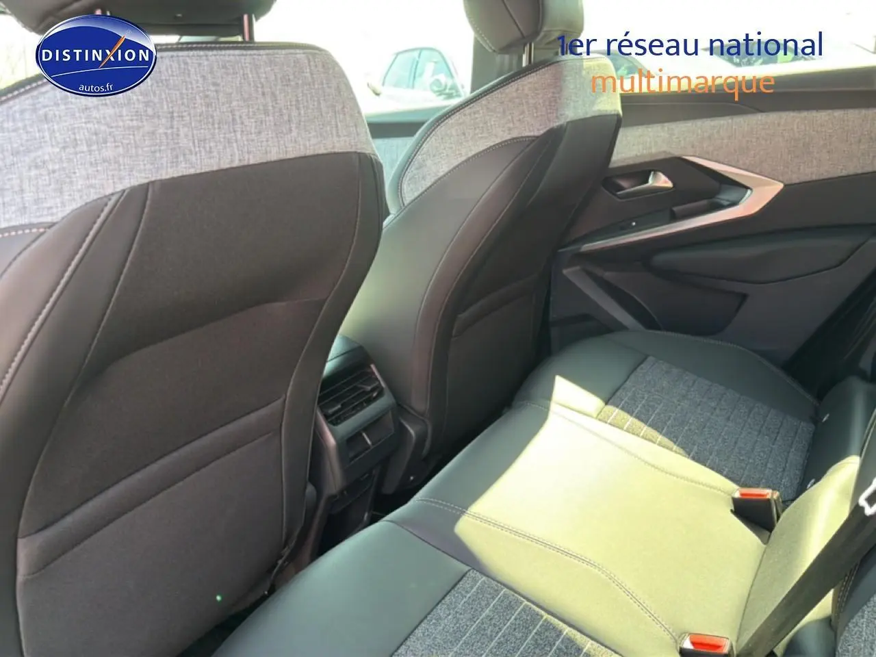 Vue intérieure arrière droite du Peugeot 3008 2025, sièges bi-matière gris et noir avec finitions tissu et cuir.