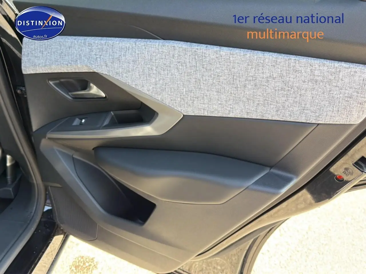 Vue intérieure de la porte avant gauche du Peugeot 3008 noir, avec habillage tissu gris et plastique noir.