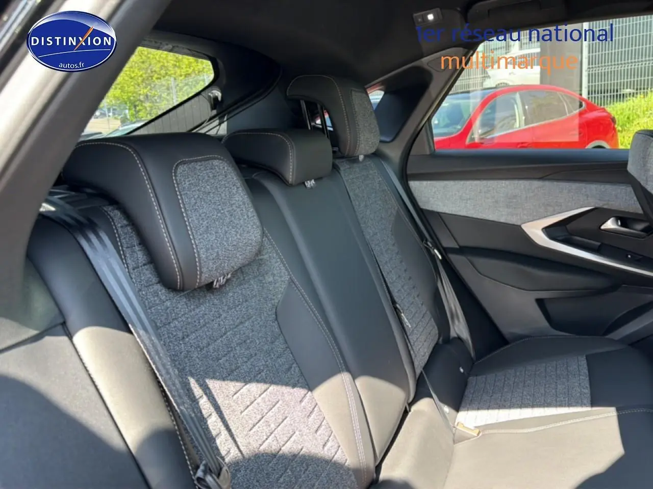 Vue intérieure sur la banquette arrière du Peugeot 3008 2025, tissu gris et cuir noir, avec porte côté droit visible.