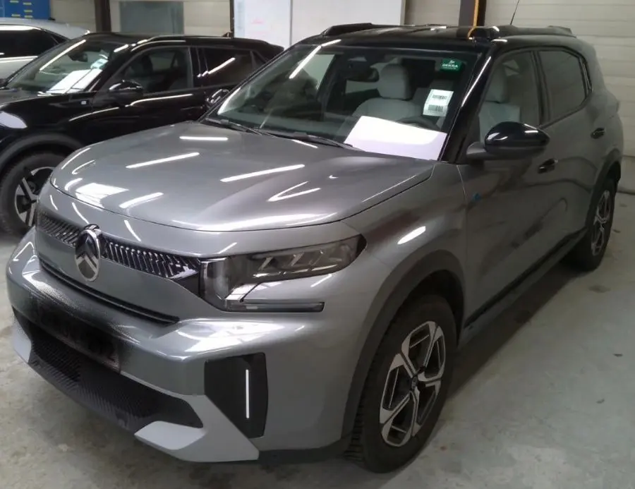Vue 3/4 avant droit d'un Citroën C3 Aircross électrique gris mercury avec toit noir et jantes 17 pouces.