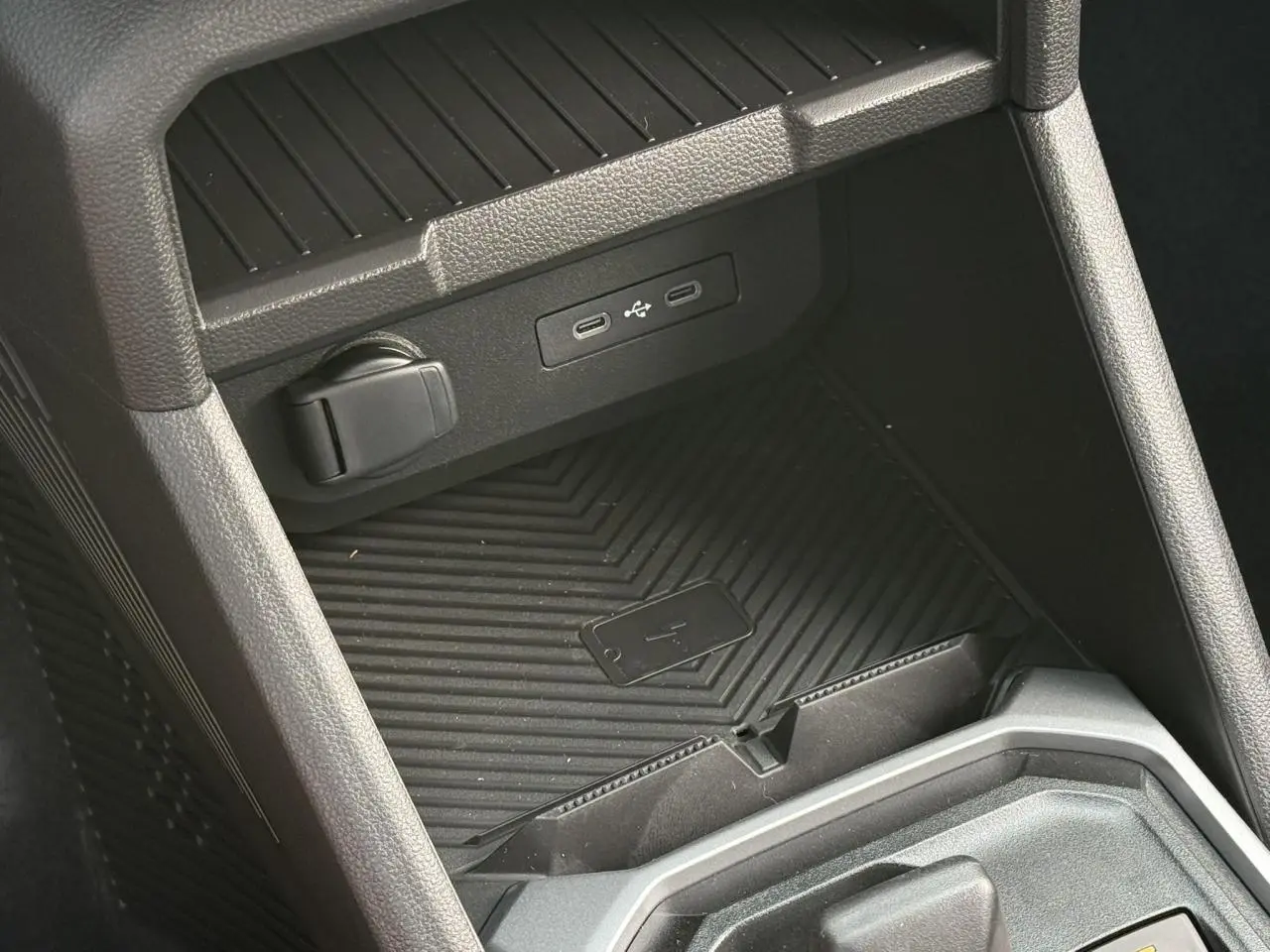 Gros plan sur la console centrale du Dacia Duster 2026, montrant le chargeur à induction et ports USB intégrés.